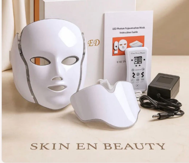 LED photon rejuvenation mask with control panel, cable, and instruction guide on a beige surface.